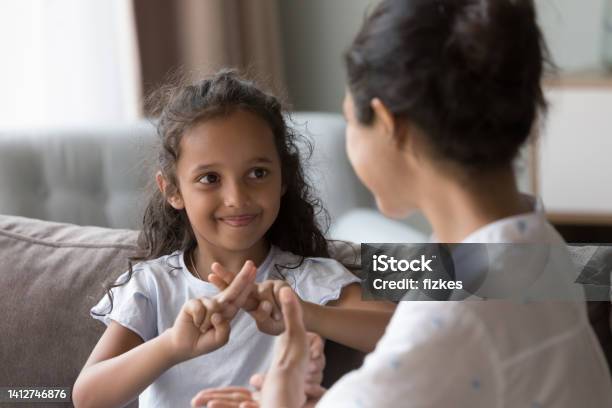 Happy Cute Indian Kid Girl Talking To Mother Using Hands Stock Photo - Download Image Now