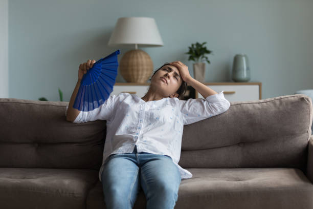 istock Exhausted young Indian girl feeling hot, resting on couch 1412746892