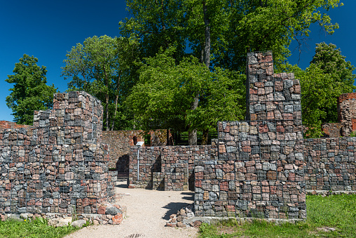 Aerial view of Koknese medieval castle ruins on the bank of Daugava river. Koknese Castle dating from the 13th century. The castle was situated on a high bluff overlooking the Daugava river valley. In 1965 a hydroelectric dam was built downriver, creating a reservoir That partially submerged flooded the castle and the surrounding valley.