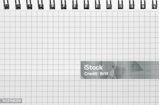 istock Checked spiral notebook background pattern, horizontal chequered squared open notepad copy space, stapled blank empty blocknote, reminder concept metaphor, large detailed macro closeup 1412748320