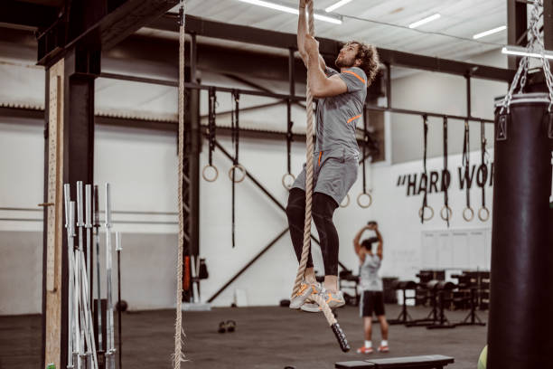 istock Male Athlete Climbing Up Rope 1412750243