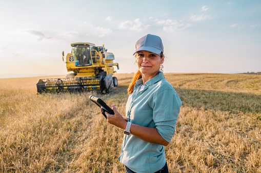 Una agricultora sostiene una tableta digital en un campo agrícola. Agricultura inteligente photo