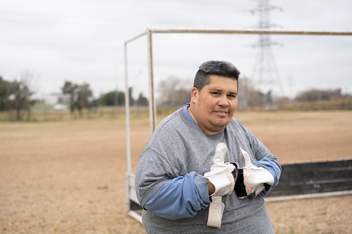 Portrait of a mentally disabled young soccer player with in front of the goal