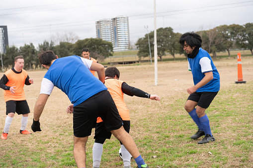 Female football players warming up before practice on soccer field.