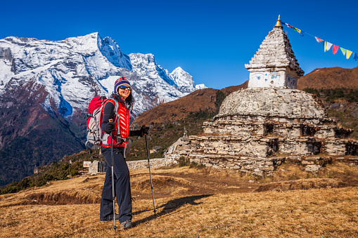 Young woman trekking in Himalayas, Mount Everest National Park. This is the highest national park in the world, with the entire park located above 3,000 m ( 9,700 ft). This park includes three peaks higher than 8,000 m, including Mt Everest.