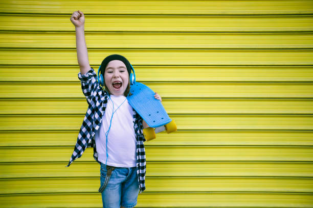 istock Little boy with headphones and skateboard 1412764359