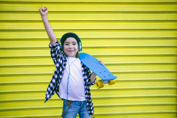 istock Little boy with headphones and skateboard 1412764366