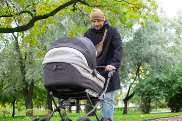 istock Happy young father with pram during the walk in nature 1412765633