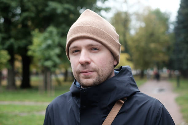 istock Young caucasian man looking at camera standing at the park 1412765641