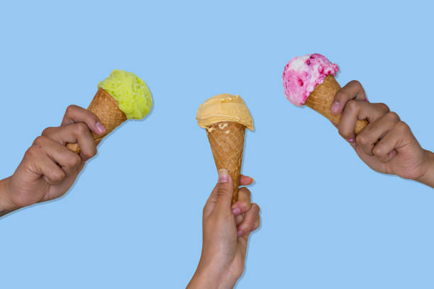 istock hands holding ice cream cones with ice cream scoops 1412766157
