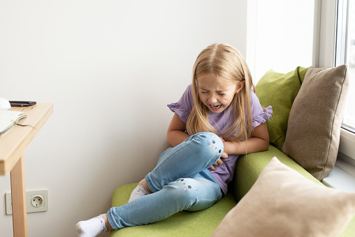 abdominal pain in a school-age child. poisoning in children. The girl presses her hands to the abdominal cavity, the tension from studying