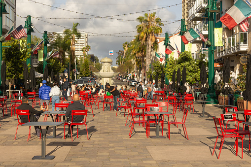 SAN DIEGO, CALIFORNIA  - APRIL 22, 2022 - The Piazza della Famiglia is located in the heart of Little Italy where it serves as a community gathering spot. The plaza is filled with red tables and chairs for people to use as they eat and drink.