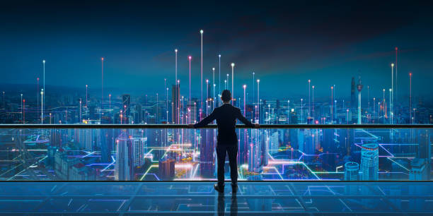 Businessman standing at transparent glass floor with night Smart city panoramic view stock photo