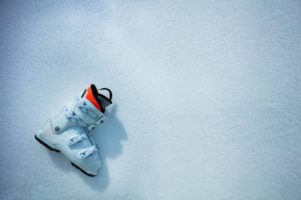 White alpine ski boot in snow view from above - winter mountains vacation concept