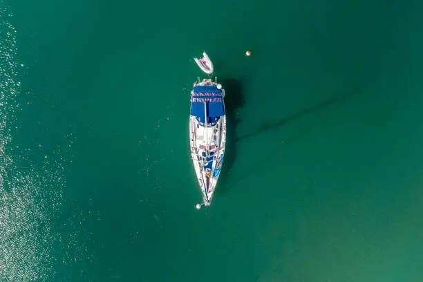Centered areal view of a Bavaria50 on anchor in green water