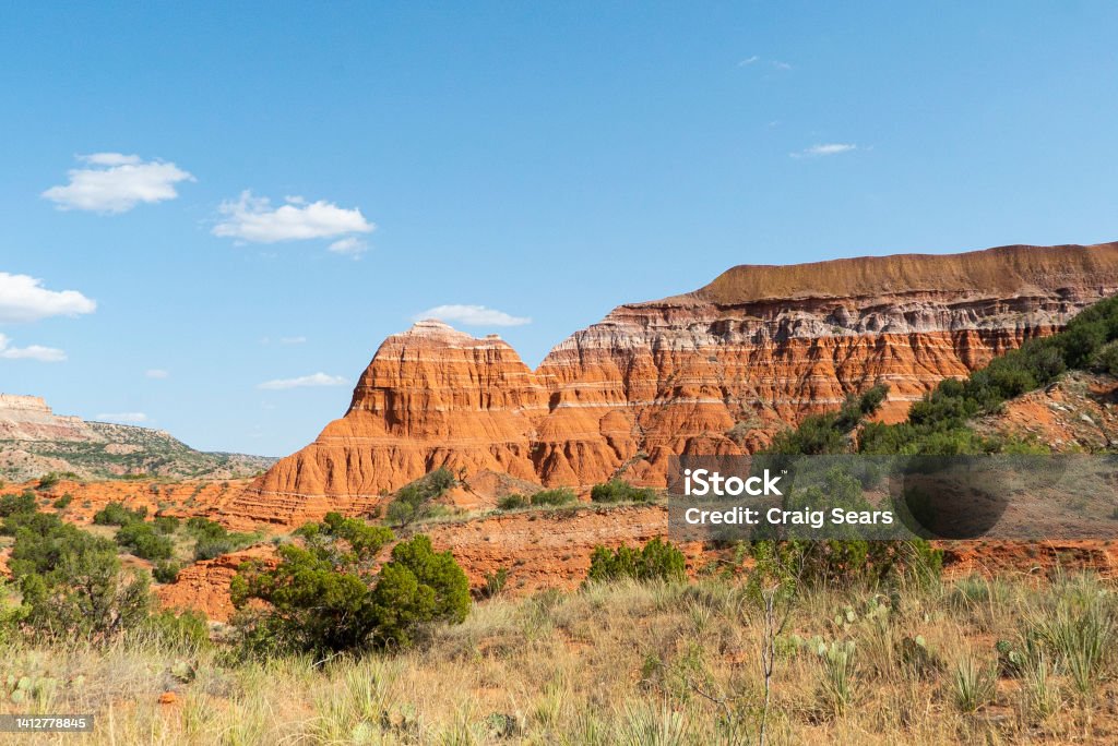 Palo Duro Canyon Red sandstone, shale and siltstone, petrified wood and caprocks form brilliant, layered monuments in the massive canyon. Hoodoos speckle the mountainsides, along with juniper and cedar, caves and arroyos. Palo Duro Canyon State Park Stock Photo