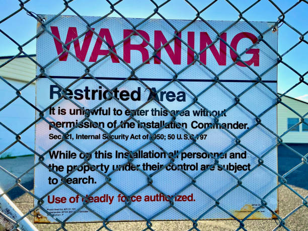 Cheyenne, Wyoming, USA - July 8, 2022: A “Warning - Restricted Area” sign hangs on the fence at a former U.S. Air Force Peacekeeper Missile Alert Facility now known as “Quebec 01 Missile Alert Facility State Historic Site” operated by Wyoming Parks.