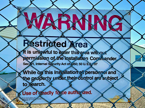 Cheyenne, Wyoming, USA - July 8, 2022: A “Warning - Restricted Area” sign hangs on the fence at a former U.S. Air Force Peacekeeper Missile Alert Facility now known as “Quebec 01 Missile Alert Facility State Historic Site” operated by Wyoming Parks.