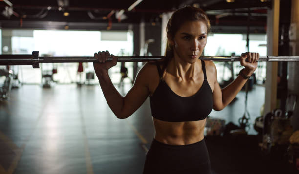 wysportowana kobieta ćwicząca ze sztangą na zajęciach fitness. ćwicz kobietę na siłowni ze sztangą. - women weight bench exercising weightlifting zdjęcia i obrazy z banku zdjęć