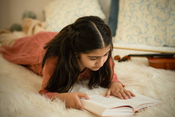 istock Young indian girl reading a book 1412786416