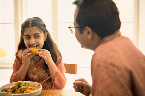 Indian girl eating some food by hand at home