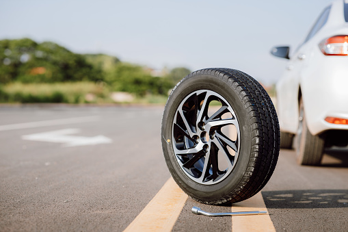 Spare wheel on the road. Concept for changing a flat tire on road.