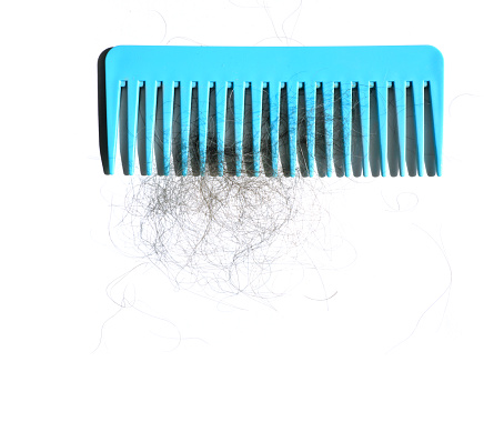 Hair loss concept of close up fallen hairs over white background