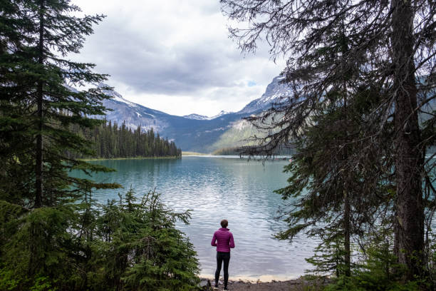 Emerald Lake in Yoho National Park. Mid adult woman hiking and exploring nature. Nature and environment themes and concepts.