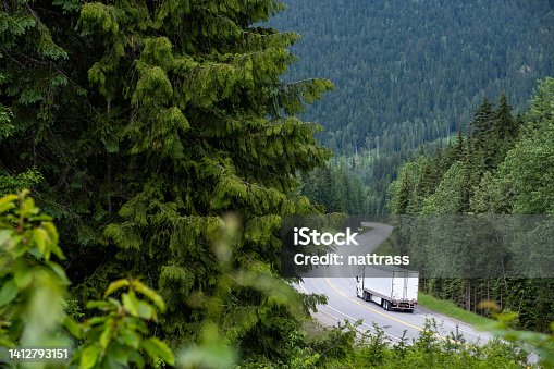 istock Container truck along a scenic road through the Canadian Rockies 1412793151