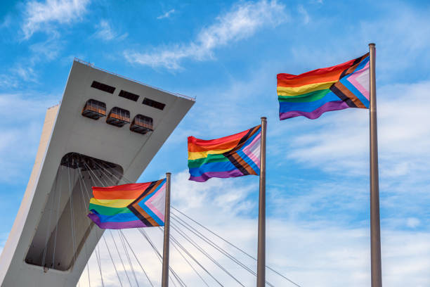 lgbtq progress pride rainbow flags in front of montreal olympic stadium - gay pride flag fotos imagens e fotografias de stock
