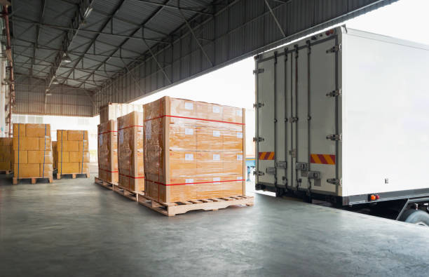 упаковочные коробки, обернутые пластиком, уложенные на поддоны, загружаются в грузовой контейнер. грузовые автомобили. отгрузка в цепочке � - semi truck cargo container mode of transport horizontal стоковые фото и изображения