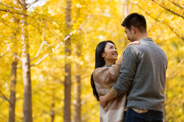 秋の森で愛情を込めて踊るカップル、ショールに身を包んだ妻 - ストックフォト - adult autumn couple face to face ストックフォトと画像