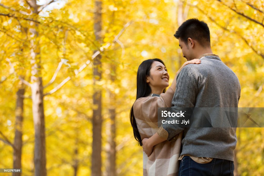Couple dancing with affection in the autumn forest, the wife draped in a shawl - stock photo Suitable for parent-child, autumn trip, family outing, close to nature, children's games, plant knowledge, children's growth, family companionship, children's painting art, forest adventure, outdoor camping, idyllic entertainment, sunset foliage, young couple in love, honeymoon for newlyweds, wedding anniversary for married couples, Mother's Day, Father's Day, Children's Day, parent-child companionship for single families, print advertising. Romance Stock Photo