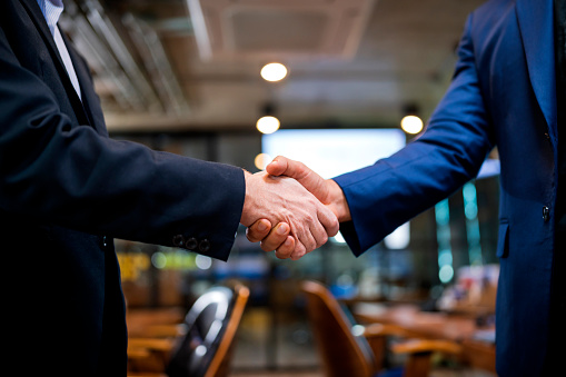 Agreement Deal Two Business people shaking hands after agree of proposal contract partners finishing up a meeting or setting goals and planning way to success in the office.Building a network towards success,handshake in contemporary office space