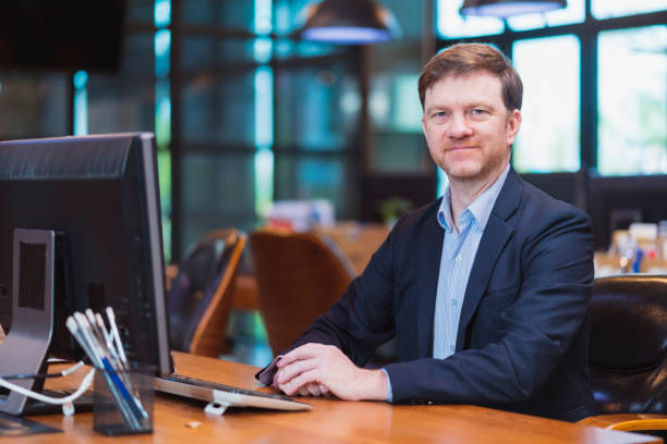 istock white caucasian office staff  programer continue working in a tech business office,Side View of Concentrate Mature businessman working at desk of a modern business office 1412797978
