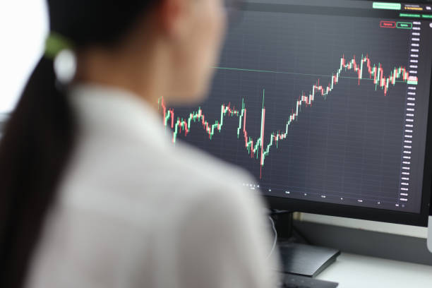 istock Happy woman trader working on pc and making technical analysis of trends 1412800295