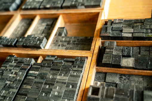 Metallic letters inside a wood drawer. The letters where used for a letterpress and printing books or newspapers.