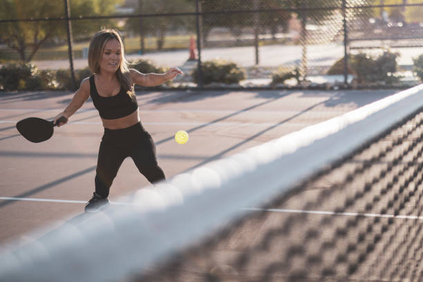 Pickle ball Girl A beautiful woman with dwarfism playing pickle ball at the park and having fun. dwarf stock pictures, royalty-free photos & images