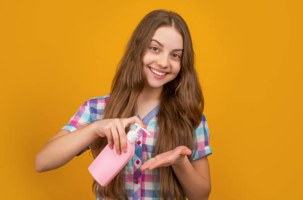 istock positive kid with liquid soap bottle on yellow background 1412807833