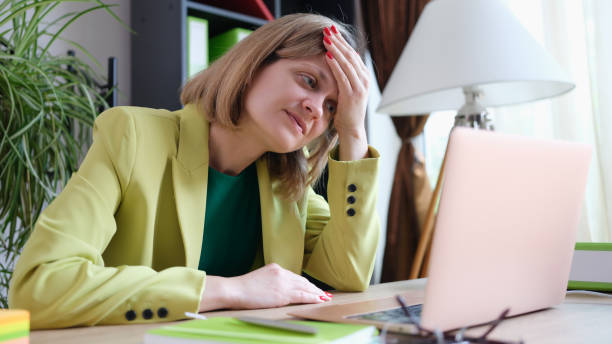 istock Tired woman working using modern laptop in office 1412808897