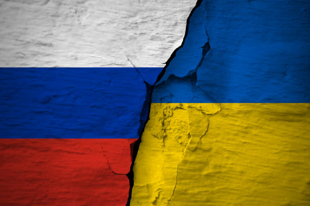 Russian Federation and Ukraine flags on the cracked concrete wall stock photo