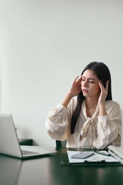 istock Stressed young businesswoman massaging temples, solving business problem. Emotional pressure, stress at work concept. 1412814789