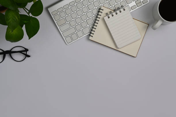istock Top view white office desk with notepad, coffee cup, eyeglasses and succulent plants. Copy space for text. 1412814811