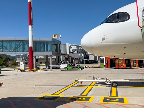 Airport, air traffic and safety concept: Standing outside the terminal building under the airplane cockpit on a sunny day. Travel and Transportation theme background, copy space.