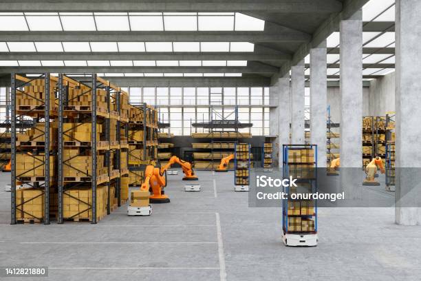 Distribution Warehouse With Automated Robots Putting Cardboard Box On Agv Stock Photo - Download Image Now
