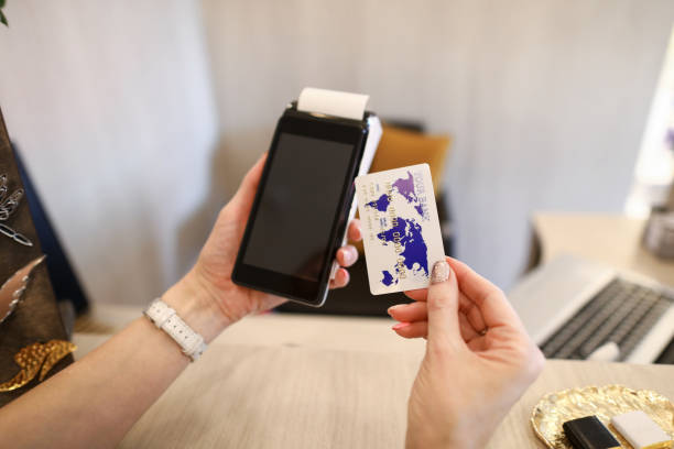 istock Close up female hands holding credit card reader 1412821885