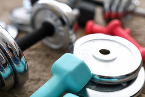 istock Pile of shiny chrome dumbbells disks lying around grip 1412821942