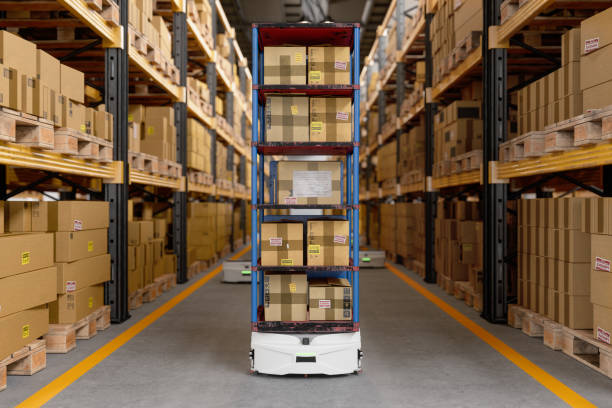 istock Interior Of Warehouse With Automated Guided Vehicle Carrying Cardboard Boxes 1412822040