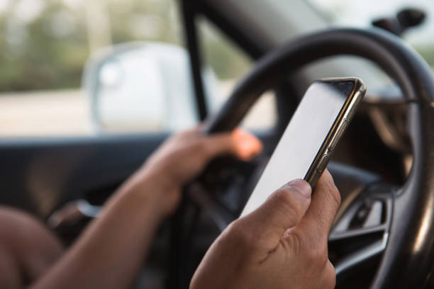istock The driver's hand behind the wheel holds a smartphone. Navigator, satellite navigation, communication in the car, road safety, speakerphone 1412822362