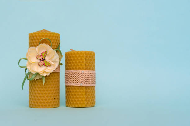 natural festive yellow beeswax candles on blue background. Space for text